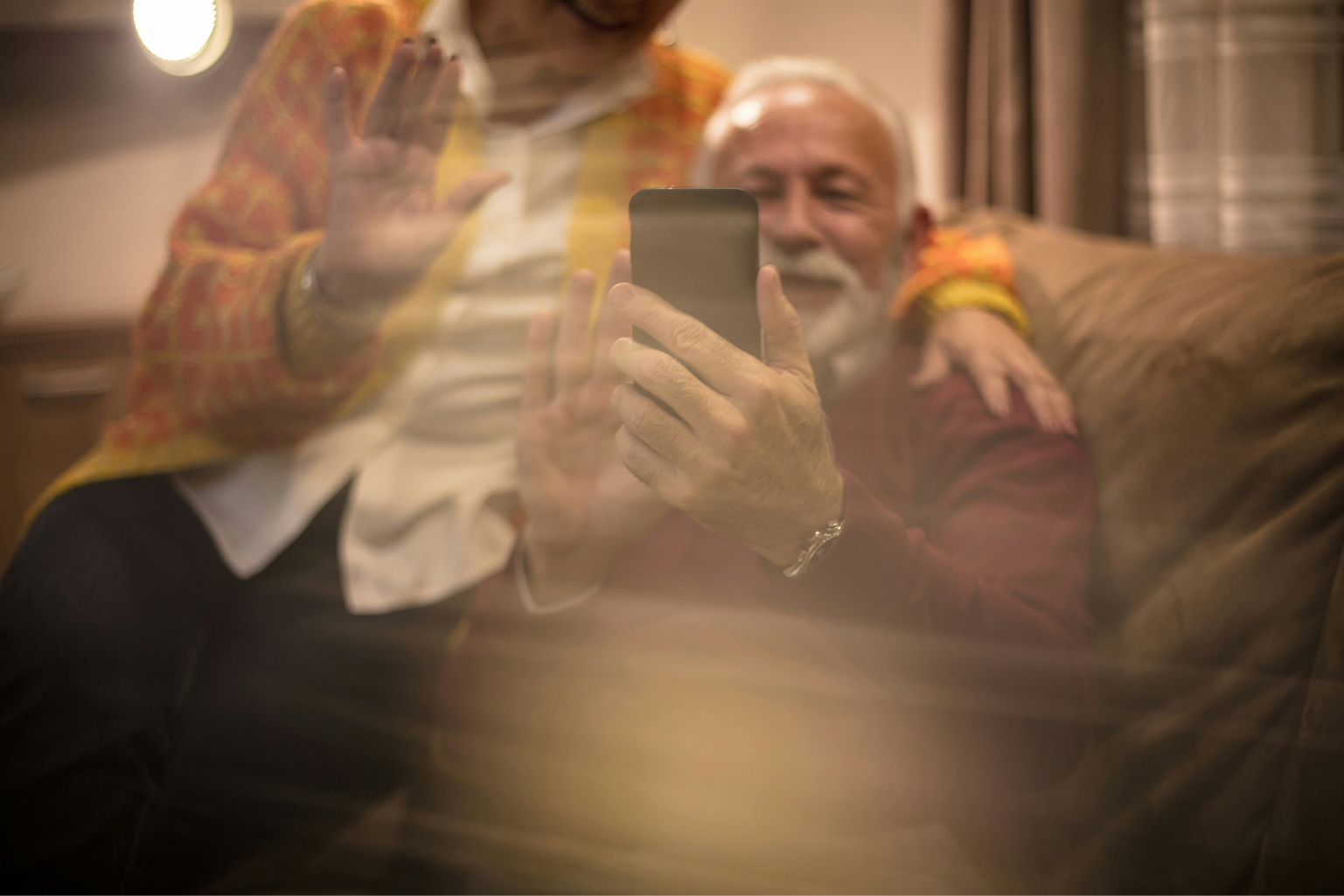 Senior couple using a phone together at home